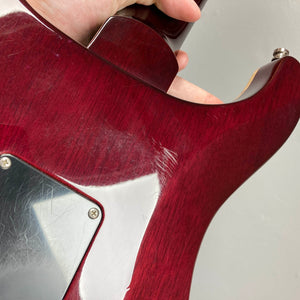 Close-up of the back of a red PRS Custom 24 Angry Larry 2011 electric guitar by PRS, showing noticeable scratches and wear near the neck joint and control plate—details that highlight its well-loved character and the distinctive tone delivered by its humbuckers. Includes case.