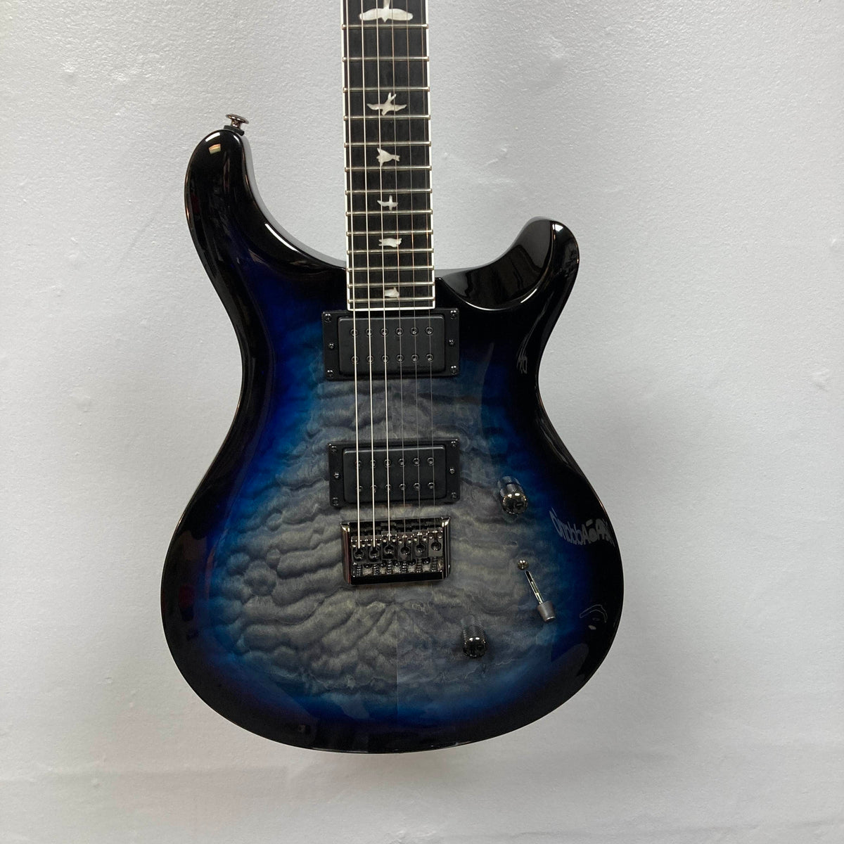 PRS SE Mark Holcomb - Holcomb Blue Burst w/Gigbag Used Consign by PRS, featuring a quilted maple top, Seymour Duncan humbuckers, and bird inlays, shown against a plain light wall.