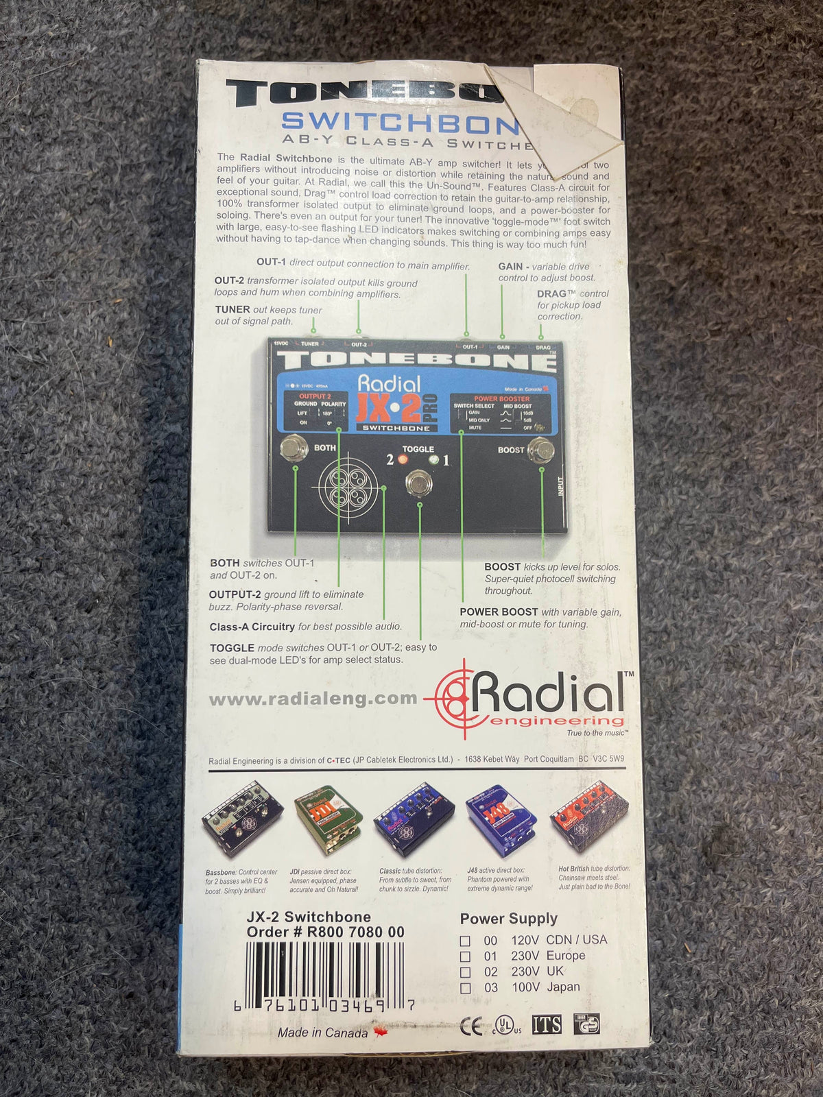 Back of a preowned Radial Engineering Tonebone Switchbone JX-2 AB-Y Class-A Switcher, showing product details, specs, and diagrams for its AB-Y amp switching and transformer-isolated output on a gray surface.