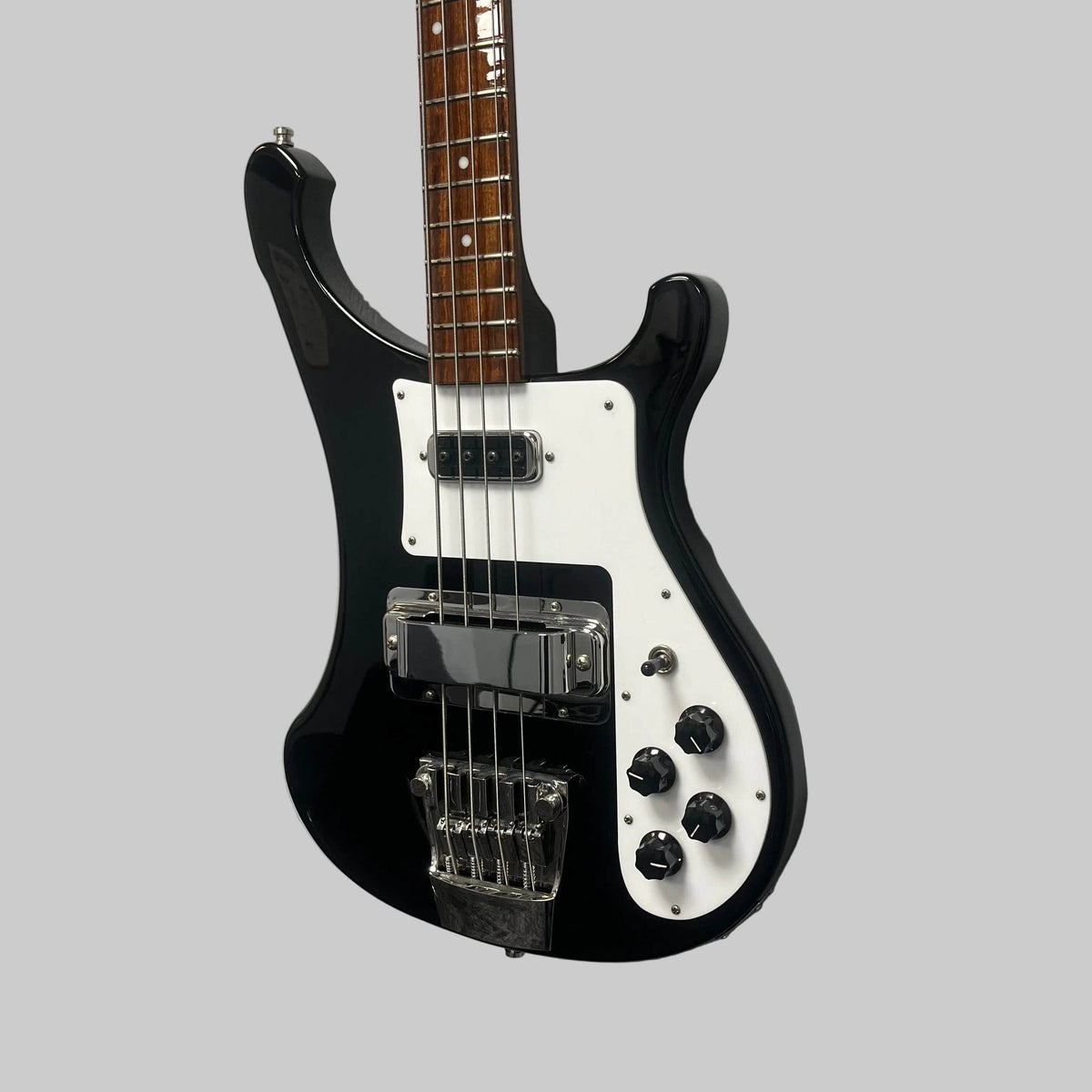 A Rickenbacker 4003 Bass Guitar – 2020 Jetglo w/Case, featuring a black and white finish, four strings, chrome hardware, and four control knobs, is mounted on a gray wall.