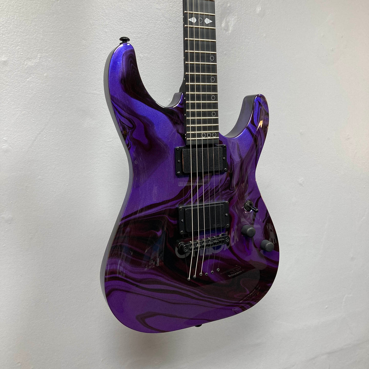 Schecter C-1 Hydro-Dip Purple Obsidian electric guitar featuring a purple and black marbled finish, two active humbucker pickups, and a dark fretboard with geometric inlays.