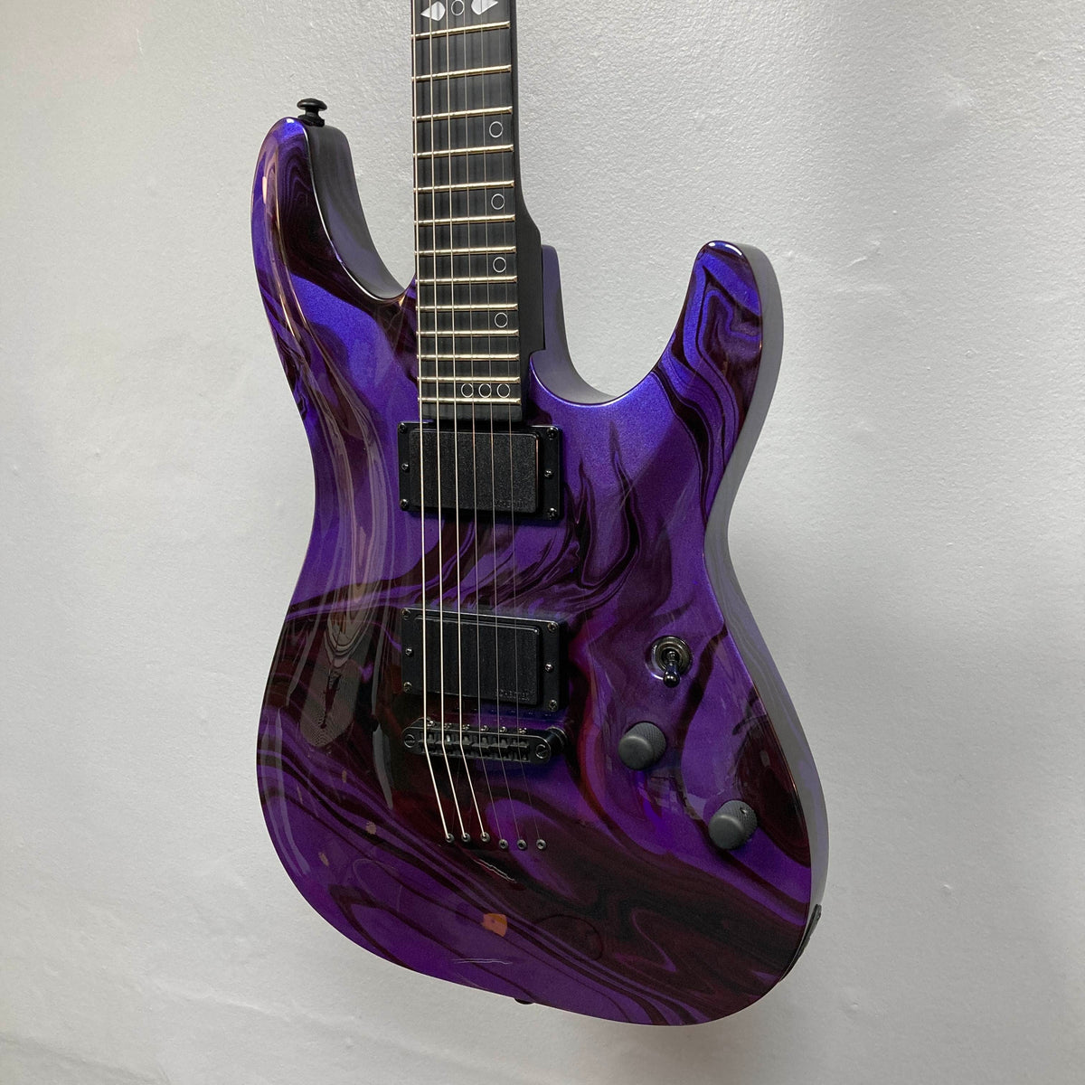Schecter C-1 Hydro-Dip Purple Obsidian electric guitar with a purple and black marbled finish, two active humbucker pickups, and circle fretboard inlays.