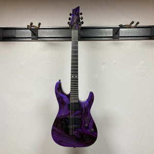 Schecter C-1 Hydro-Dip Purple Obsidian electric guitar with a purple and black marbled finish, hanging on a wall mount.