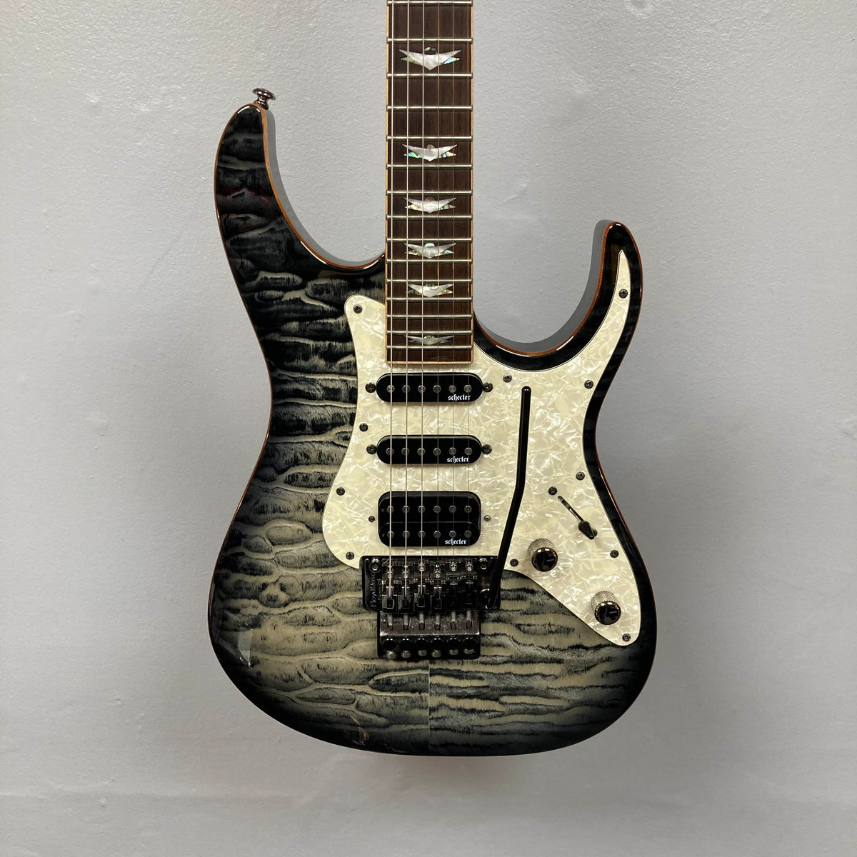 Schecter Extreme Banshee 6 FR CHARCOAL BURST Electric Guitar w/case by Schecter, featuring a quilted maple top, three pickups, pearloid pickguard, five control knobs, and a tremolo bridge, photographed on a plain light gray background.