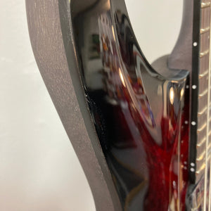 Close-up of the Schecter Omen Elite-7 Multiscale Black Cherry Burst guitar, highlighting its finish blemishes and 7-string configuration.