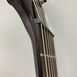 Close-up of the Schecter Omen Elite-7 Multiscale Black Cherry Burst guitar neck, highlighting its strings and fretboard details.