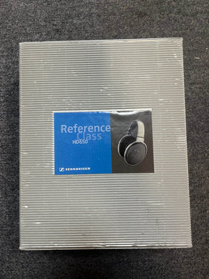 A closed box of Sennheiser HD 650 Reference Class Headphones - Preowned by Sennheiser is displayed on a gray carpeted surface.