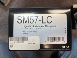 Box of a used Shure SM57-LC Legendary Instrument Microphone by Shure, showing product label, barcode, $158 price tag, and included accessories: mic clip and mic bag.