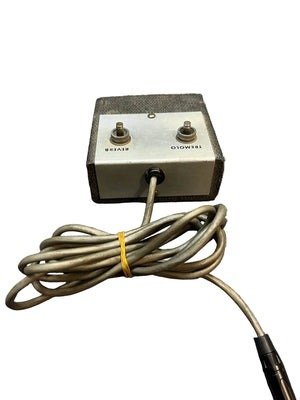 The Silvertone 1484 Tremolo Reverb Footswitch 1960s - Gray is a compact metal box with two labeled toggle switches, a coiled attached cable, and an end connector, reminiscent of classic '60s Silvertone gear, shown on a white background.