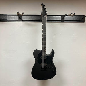 Spira T-400 MBK Electric Guitar - Black, featuring a single-cutaway, dual humbuckers, and six-inline headstock, elegantly displayed on a wall rack.
