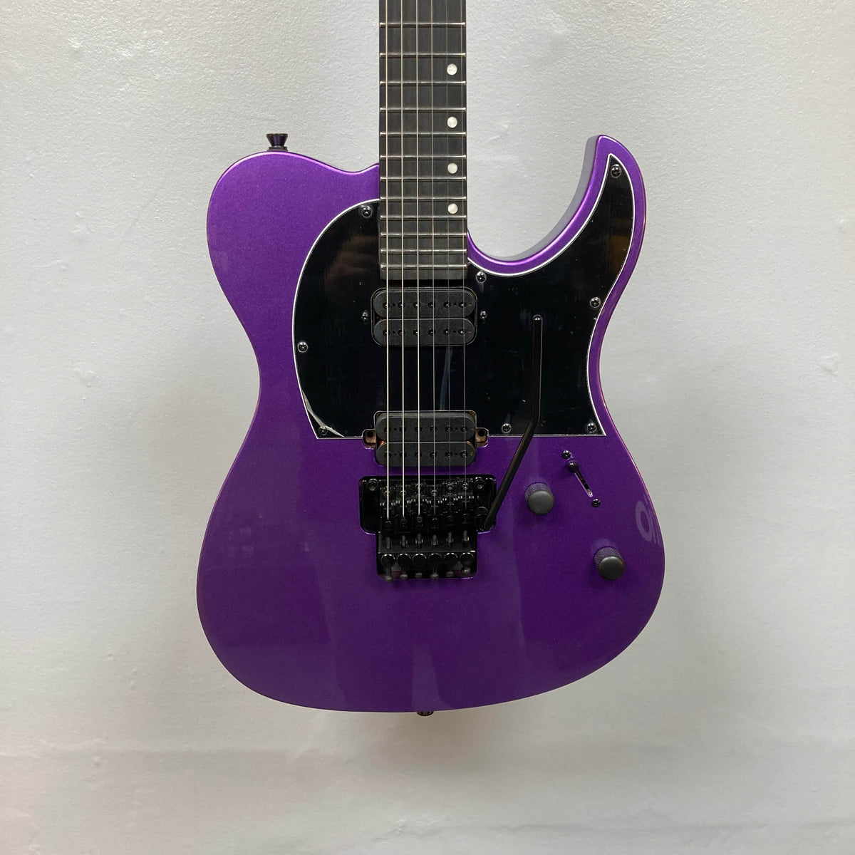 The Spira T-420 PP by Spira is a purple electric guitar with a black pickguard, two control knobs, high-output humbuckers, and a whammy bar, shown against a plain white background.