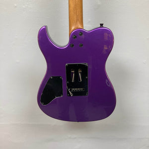 The back of a Spira T-420 PP electric guitar by Spira, featuring a purple finish, roasted maple neck, black plastic cover plates, and exposed screws, set against a plain white wall.