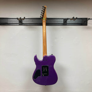 A Spira T-420 PP electric guitar by Spira, in purple with a roasted maple neck and missing backplates that show the wiring, hangs on a wall-mounted rack and is photographed from the back against a white wall.