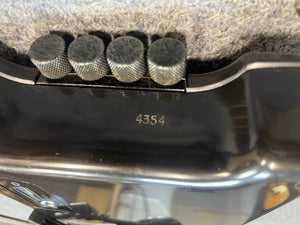 Close-up of a 1984 Steinberger XL-2 Bass USA, featuring five grooved knobs with "4354" engraved below. Above the knobs, a textured grey fabric adds a classic vintage Steinberger touch to this iconic headless bass.