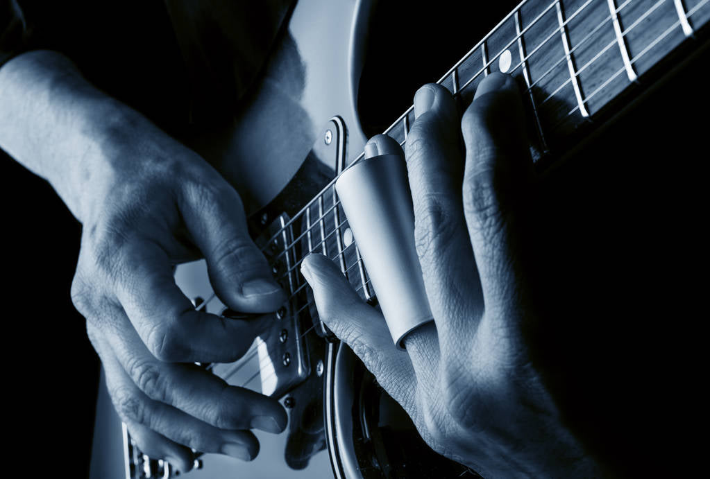 Stock photo of hands playing slide blues guitar