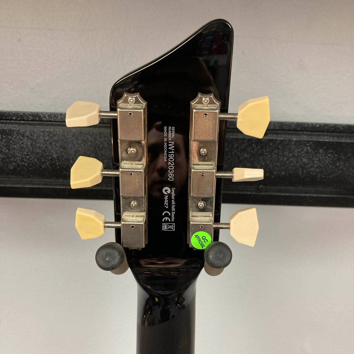 Back view of a Supro 1296 Silverwood British Racing Green w/Gigbag Used guitar headstock, featuring four tuning pegs, serial number, manufacturer details, and a green QC sticker against a plain background.