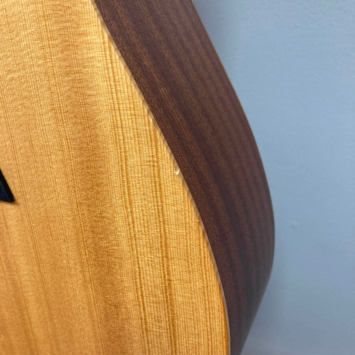 Close-up of the wooden body and side of a Taylor Academy 10e Acoustic-Electric Guitar.