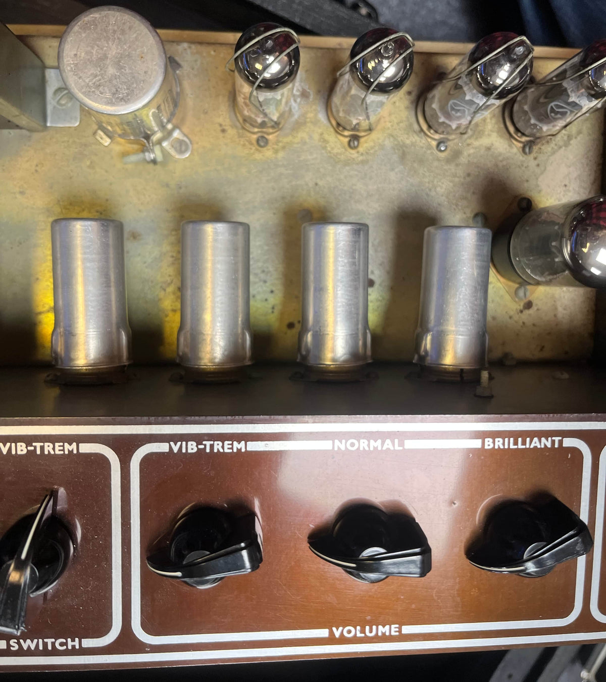Close-up of a Vintage 1963 Vox AC30/6 Normal amplifier control panel by Vox, featuring labeled knobs, switches, visible vacuum tubes, metal covers, and original JMI Egg Footswitch with Flight Case—all delivering classic tone.