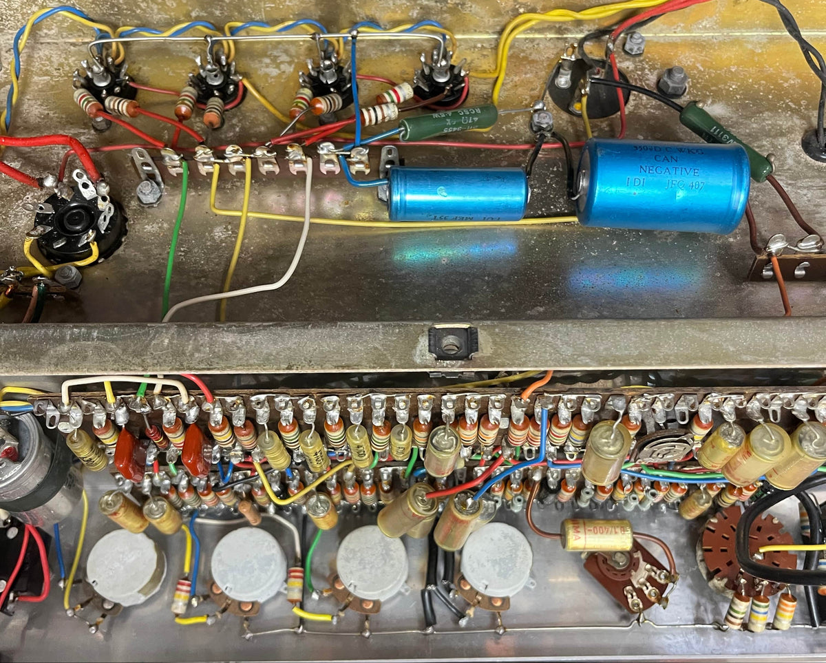 Close-up view of the internal wiring and electronic components—capacitors, resistors, Woden transformers, and circuit board—inside a Vintage 1963 Vox AC30/6 Normal by Vox, with original JMI egg footswitch and flight case.