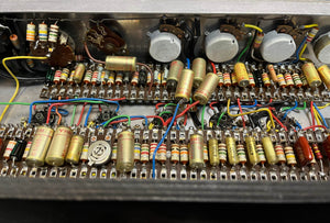Close-up of a vintage circuit board with resistors, capacitors, wires, and potentiometers, featuring classic Woden transformers from the 1963 Vox AC30/6 Normal by Vox, including original JMI egg footswitch and flight case.