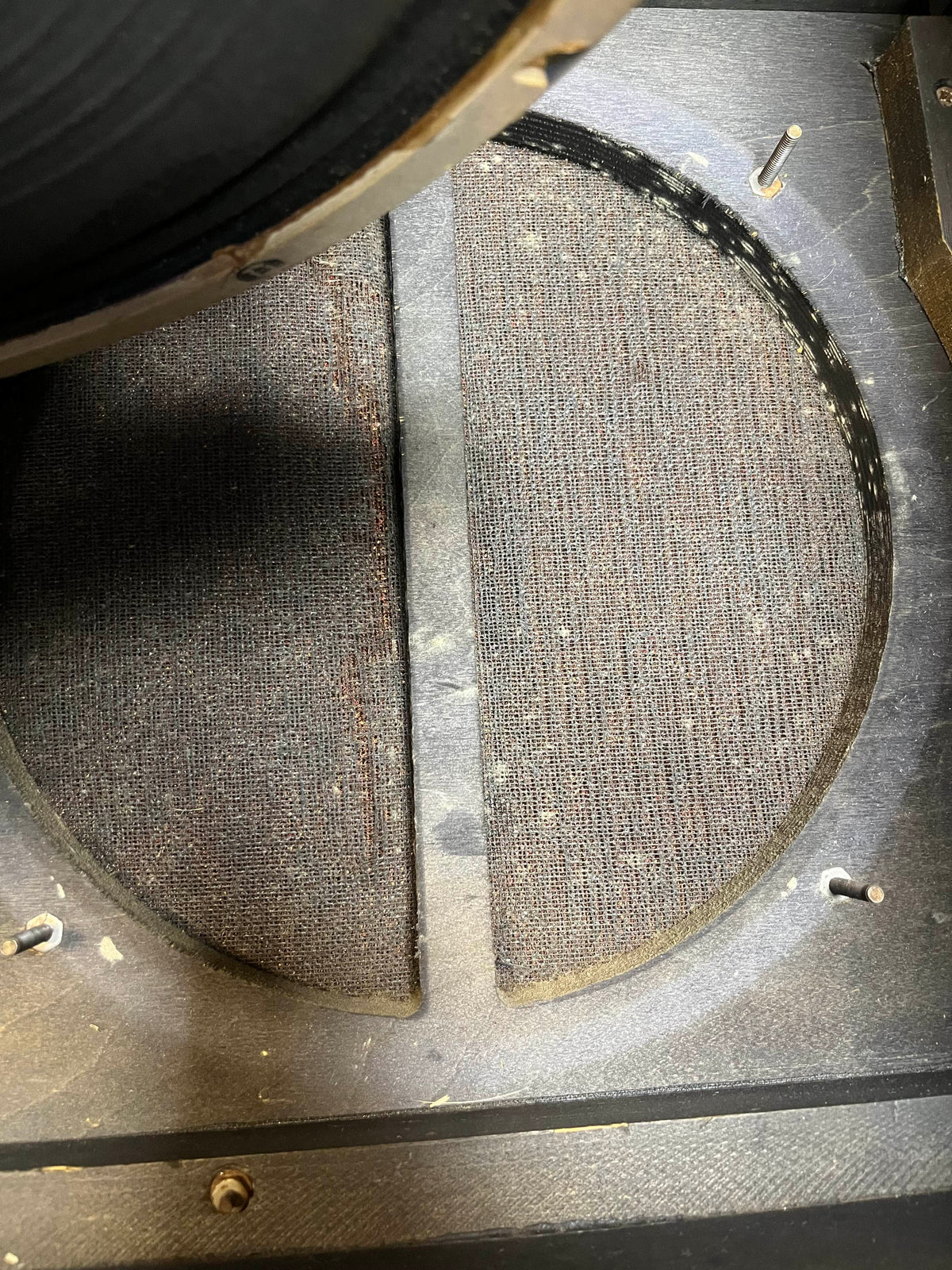 Close-up of an empty speaker cabinet with circular opening and fabric back panel—ideal for a Celestion Blue T530, just like those in the Vintage 1963 Vox AC30/6 Normal by Vox, complete with original JMI egg footswitch and flight case.