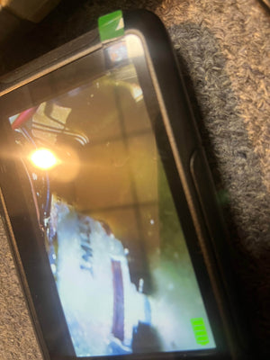 Close-up of a smartphone screen showing a magnified electronic component—reminiscent of those in a 1971 Marshall 50W Lead Head, JMP Era, by Marshall—set beside textured fabric, evoking classic British guitar amp style.