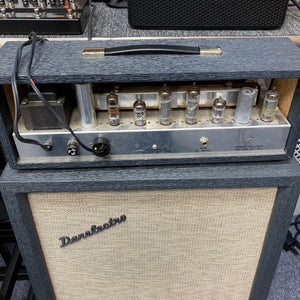 Vintage Danelectro DM-25 1960s guitar amp close-up, featuring the iconic retro tombstone design, prominent tube elements, and controls for bass, treble, and volume.