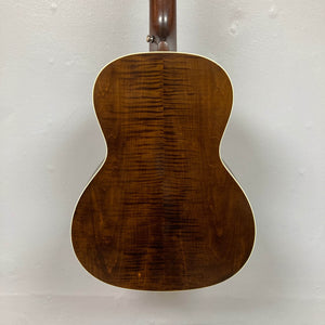 The Waterloo WL-12 Parlor Acoustic w/Case Used Consign by Waterloo features a glossy, dark brown back with visible wood grain and white binding, photographed against a plain white wall.