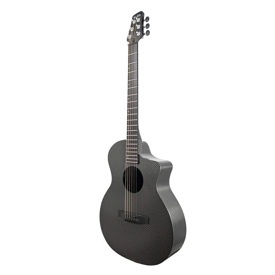 The Klos Full Carbon Grand Cutaway Mini DAE w/Fishman Presys VT, a black carbon fiber travel guitar with six strings and a glossy finish, stands upright against a white background.