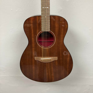 A Yamaha Storia III Solid Mahogany Top Concert guitar with a glossy finish hangs against a plain white wall.
