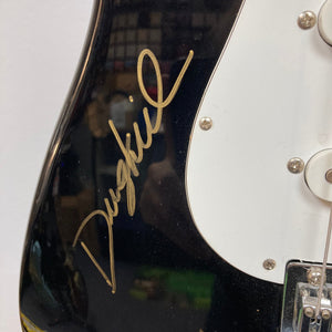 Close-up of a Strat-style guitar signed by ZZ Top members, available at Guitars on Main.