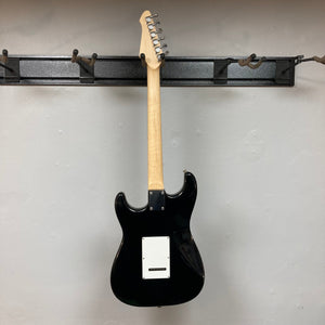 ZZ Top Signed Strat Style Guitar with a wooden neck and white square plate, displayed on a wall hook.