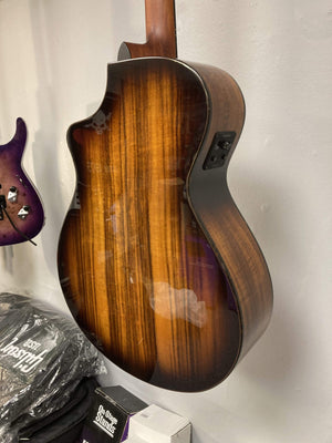 Breedlove Pursuit Exotic S Concert Edgeburst CE Koa-Koa guitar mounted on a wall, showcasing its elegant design and craftsmanship.