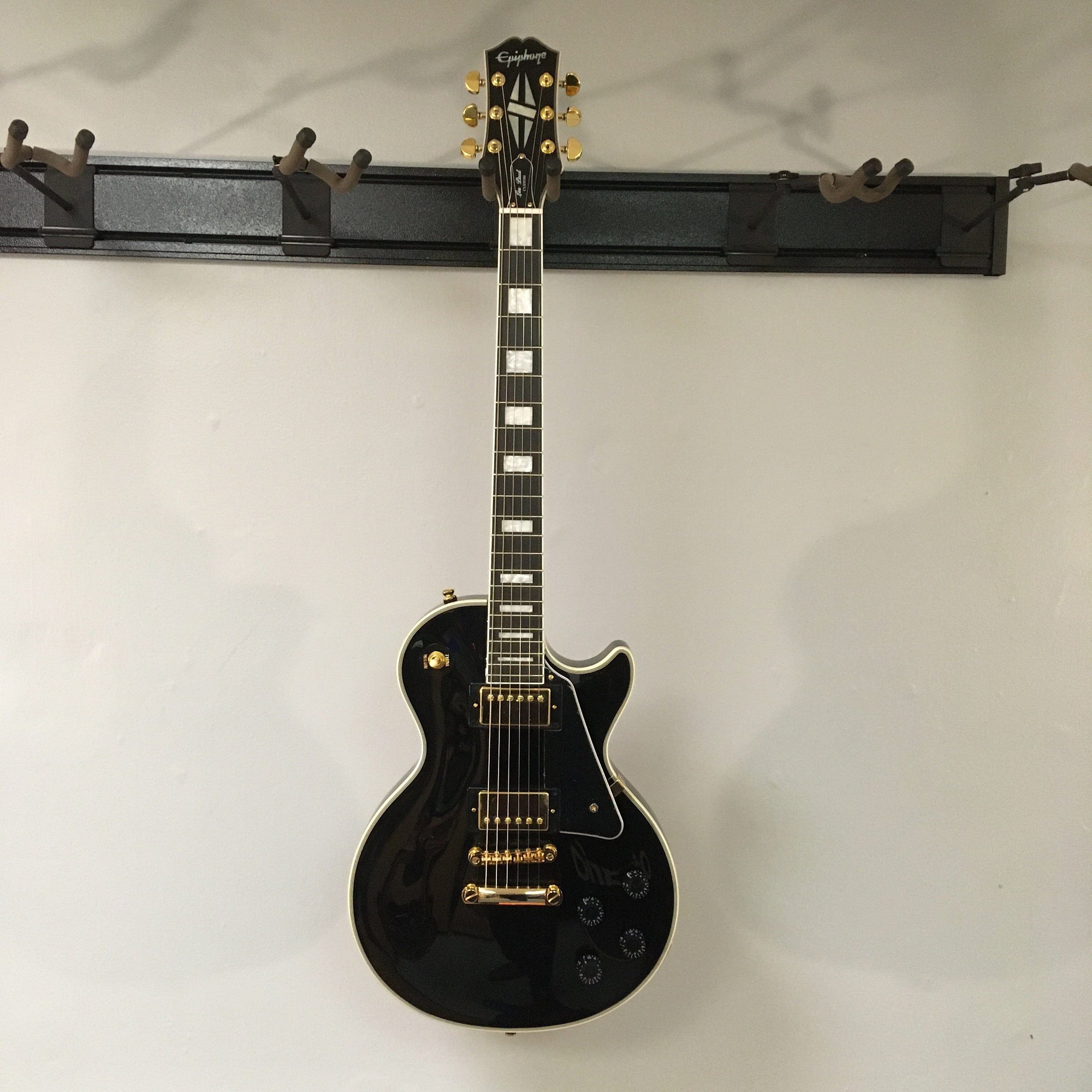 2022 Epiphone Les Paul Custom Ebony features gold hardware and white binding, equipped with Gibson pickups. Includes a Gator case for protection.