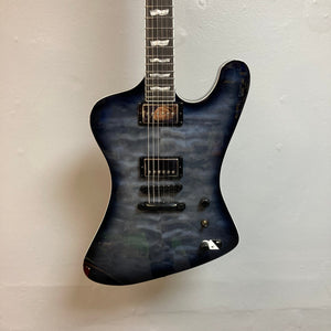 ESP LTD Phoenix-1000 QM See-thru Black Sunburst electric guitar hanging on a wall.