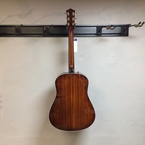 Godin Metropolis LTD Havana Burst HG EQ SF guitar mounted on a wall, showcasing its craftsmanship and acoustic features.