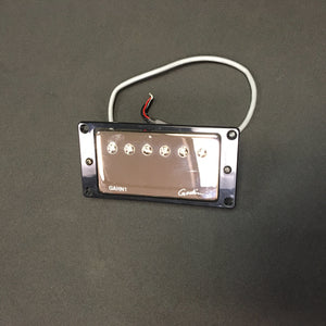 Close-up of a Godin Neck Humbucker pickup with NICKEL cover, featuring a black rectangular design and attached wire. Ideal for enhancing guitar sound.