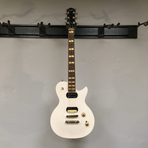 Godin Summit Classic HT Trans White Open Box electric guitar with black and gold hardware, displayed on a wall.