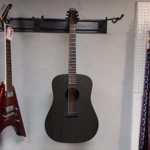 Klos Full Carbon Deluxe Acoustic Electric Guitar mounted on a wall, showcasing its durable carbon fiber body and neck.