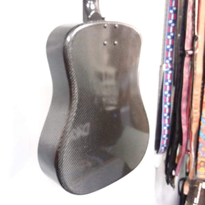 Klos Full Carbon Deluxe Acoustic Electric Guitar in a durable carbon fiber case hanging on a wall, showcasing its robust build ideal for travel.