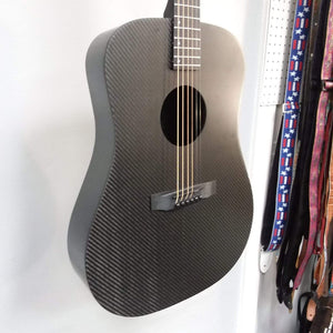 Klos Full Carbon Deluxe Acoustic Electric Guitar on display, featuring durable carbon fiber body, visible strings, and a custom gig bag strap.