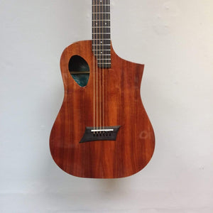 Michael Kelly Forte Koa Jr. travel guitar displayed on a wall, highlighting its compact size and detailed craftsmanship, ideal for gigs and travel.