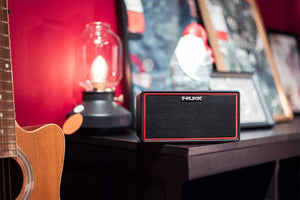 NUX Mighty Air wireless stereo guitar/bass amplifier on a table, featuring Bluetooth connectivity and dual speakers for high-quality sound.