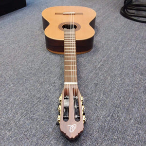 Ortega Nylon String Guitar R189SN-25TH with gig bag, featuring a solid cedar top, lying on the floor.