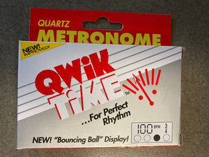 Qwik Time QT-5 Quartz Metronome in packaging, featuring a digital display and a fold-out stand, ideal for beginner musicians.