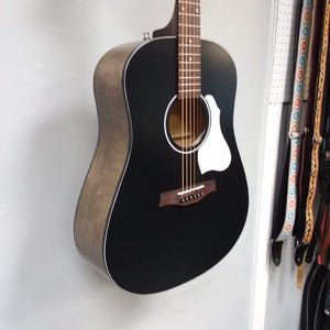 Seagull S6 Classic A/E Black guitar mounted on a wall, showcasing its semi-gloss finish and visible strings.