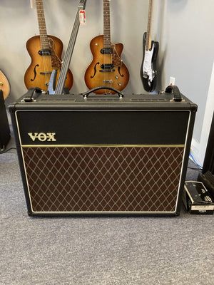 Vox AC30C2 amp with guitars on stands, showcasing its iconic design and powerful sound capabilities.