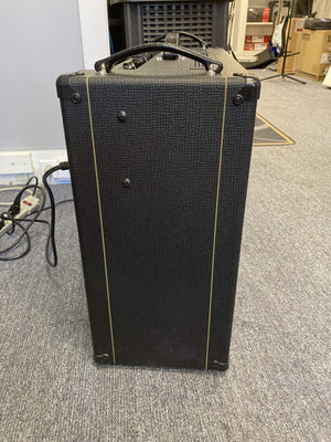 Vox AC30C2 amplifier with gold stripe, black cord, and dual 12” Celestion speakers, known for its iconic British Invasion sound and powerful 30-watt output.